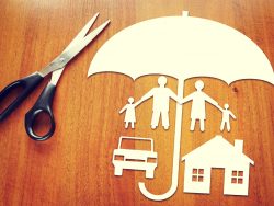 Formes de parapluie, d'une famille, d'une auto et d'une petite maison découpée dans du papier, un ciseau est posé à côté.