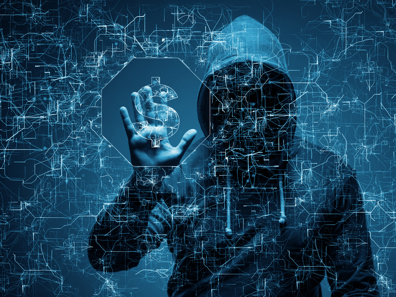 Un homme cagoulé qui a l'air très suspect. Il a une main posée sur un écran transparent sur lequel apparaît des signes informatiques.