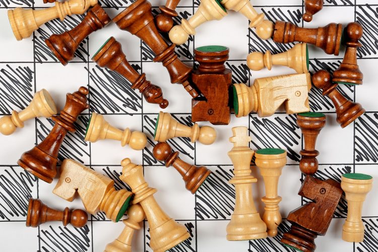 43691983 – wooden chess pieces scattered on hand drawn chessboard alternate text for this image