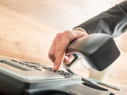 Un homme d'affaire tapant sur son clavier de téléphone pour passer un appel.