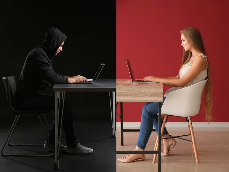 Une femme écrivant sur un clavier à un homme qui a une capuche et a l'air louche.