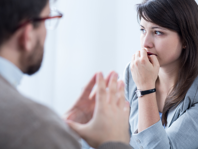 Un conseiller qui explique un sujet délicat à une jeune femme angoissée.