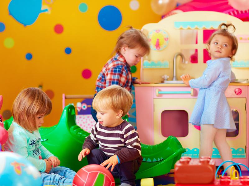 Quatre enfants en train de jouer dans une école maternelle.