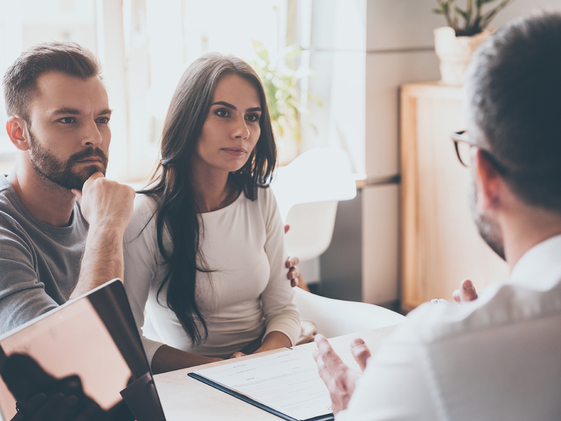 Un couple concentré écoutant un conseiller financier.