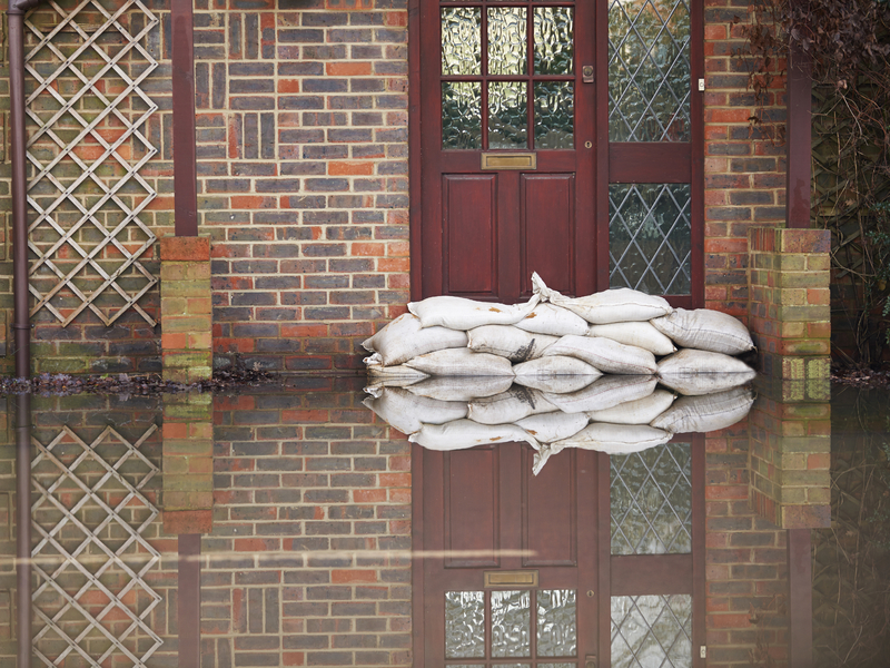 L'entrée d'une maison avec pleins de sacs de sable devant pour éviter qu'elle ne soit inondée.