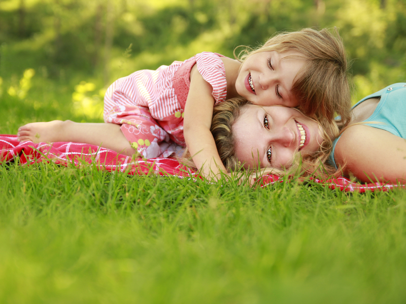 Une femme et sa fille allongée dans l'herbe.