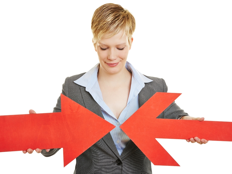 Une femme d'affaires faisant converger une flèche rouge, avec une autre flèche rouge plus large.