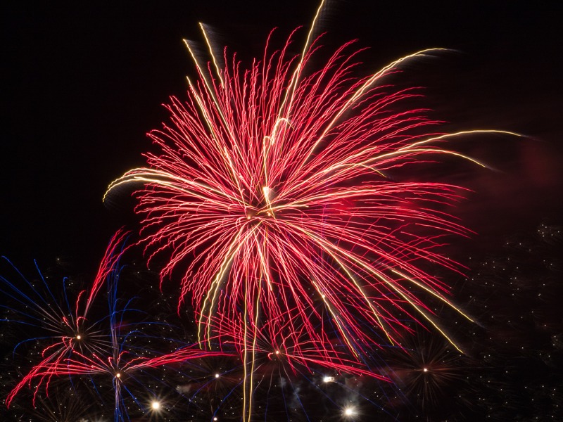 Un feu d'artifice rouge dans un ciel de nuit.