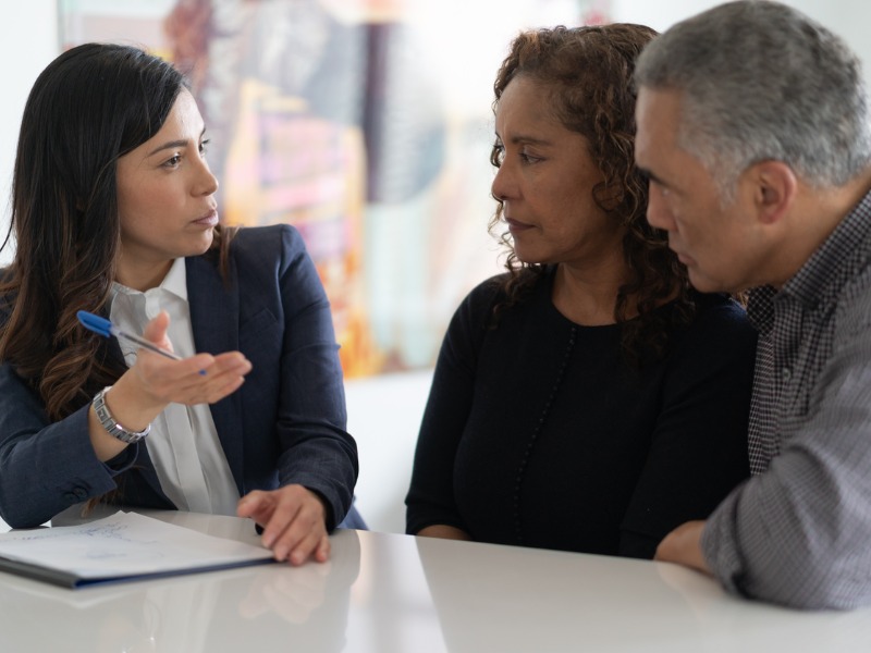 Une conseillère explique à un couple son plan.