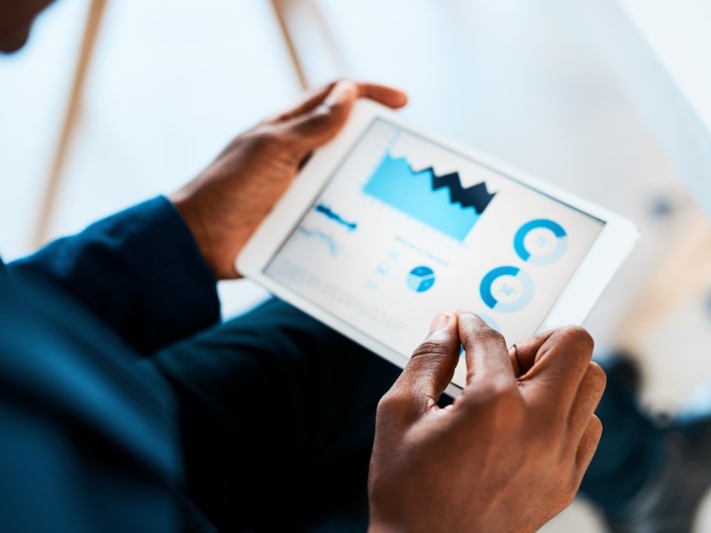 Un homme de couleur regarde des graphiques financiers sur une tablette.