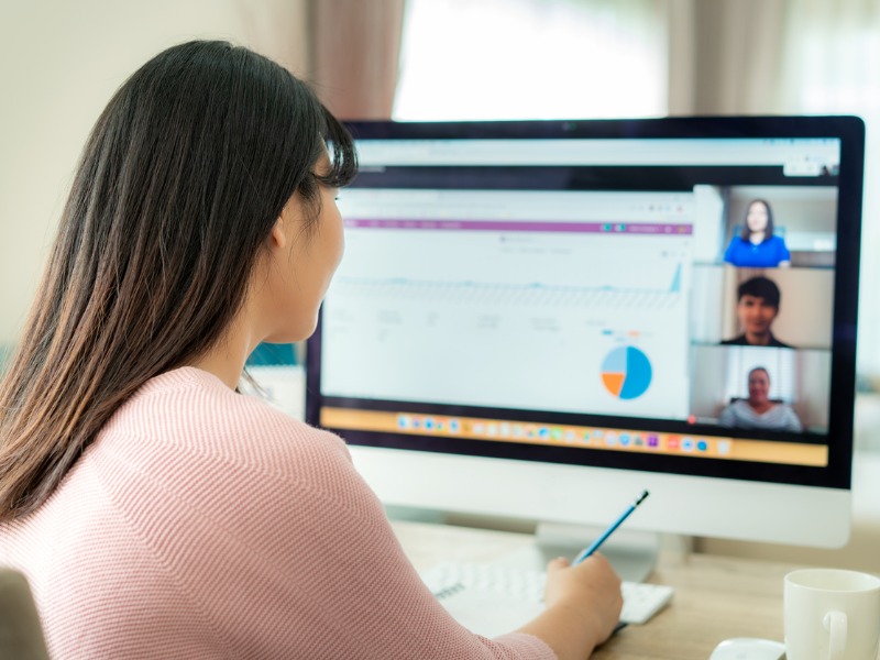 Une femme faisant du télétravail en skypant avec ses collègues.