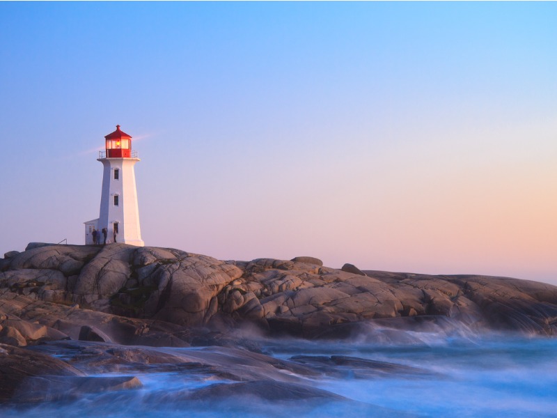 Un phare allumé au soleil levant.