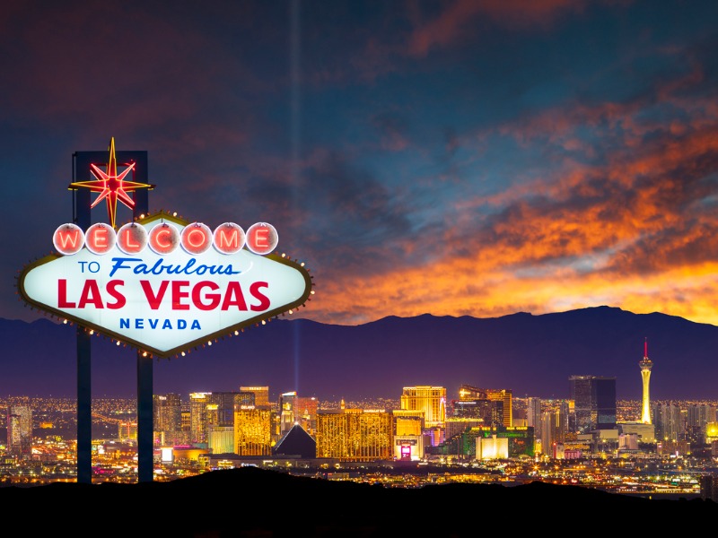 Une photo d'un panneau annonçant la ville de Las Vegas, avec la ville en arrière,