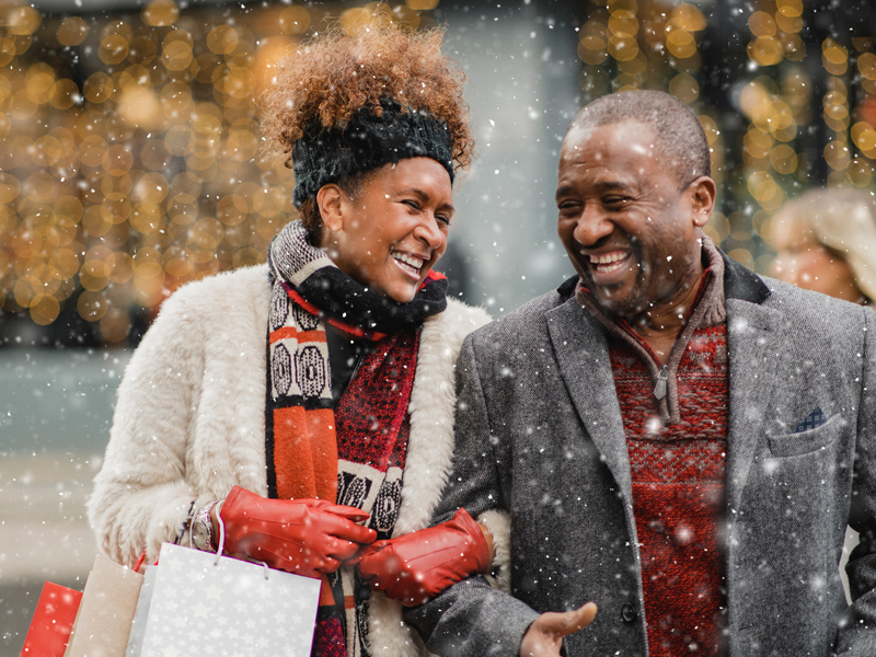 Couple plus âgé souriant l'un à l'autre, avec de la neige dans l'air