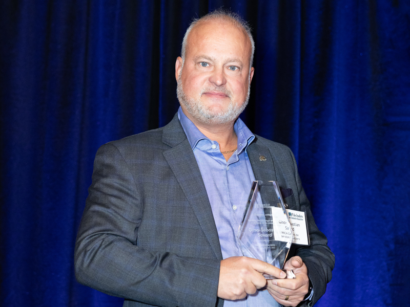 Photo de Gino-Sébastian Savard avec son prix du Top des leaders de l'industrie financière 2023-2024