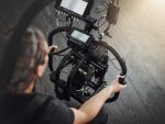 Un caméraman tenant une caméra avec un stabilisateur.