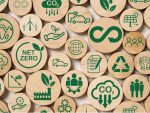 Des jetons en bois sur lesquels on peut voir plusieurs dessins en vert symbolisant des concepts reliés à la finance durable.