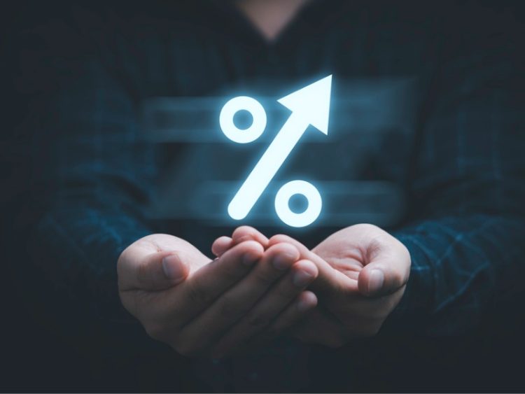 Homme d’affaires tenant un symbole de pourcentage lumineux pour la planification financière et le concept de politique de croissance des taux d’intérêt.