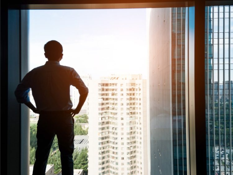 Homme d’affaires par le biais de la fenêtre à la recherche de la ville