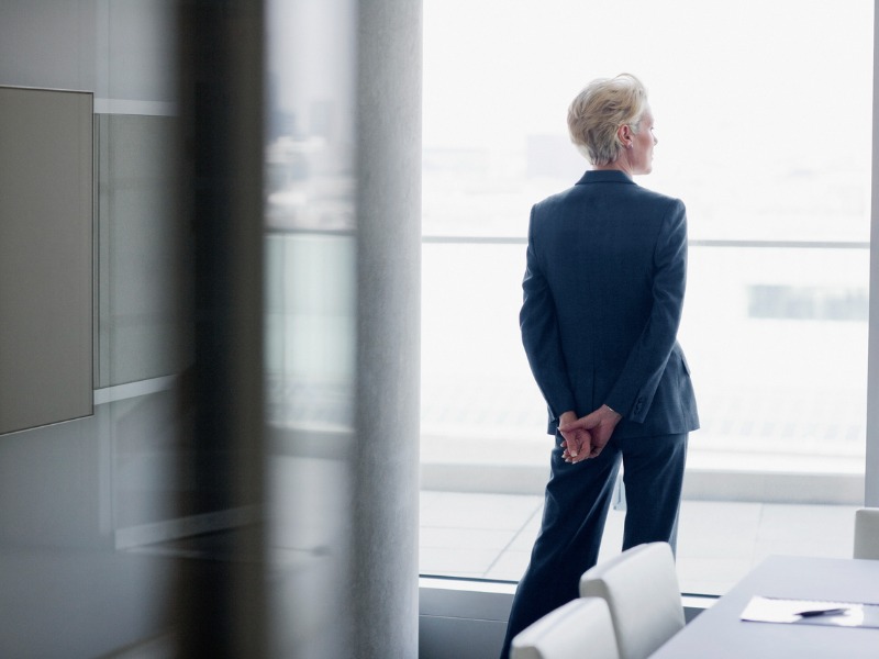 Femme d'affaires debout à la fenêtre dans le bureau.