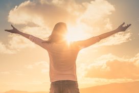 Jeune femme avec les mains levées la lumière du soleil du matin trouver le bonheur, la paix et l’espoir dans la nature.