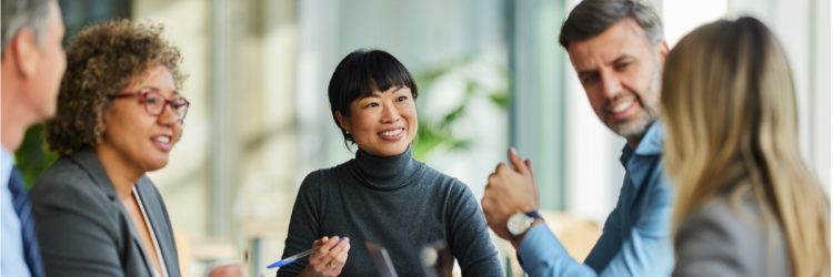 Une équipe multiraciale heureuse discute lors d'une réunion au bureau.
