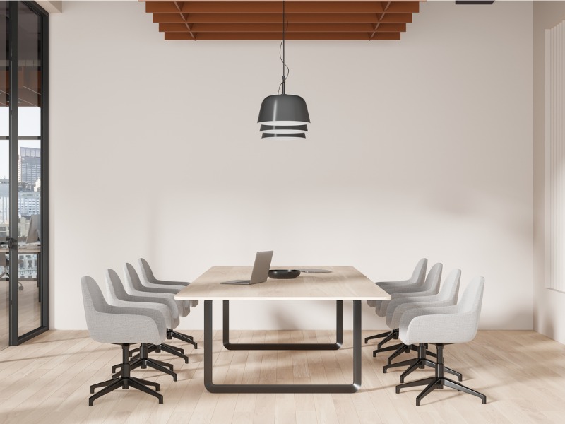 Salle de réunion confortable avec table et chaises, écran de télévision et fenêtre panoramique.