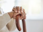 Des mains d'une personne d'un certain âge, posées sur une canne