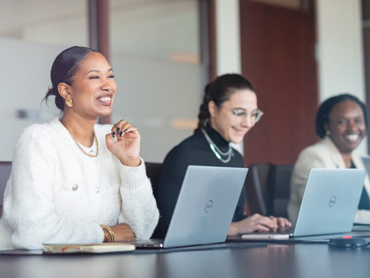 Filles souriantes dans un environnement de bureau avec des laptops
