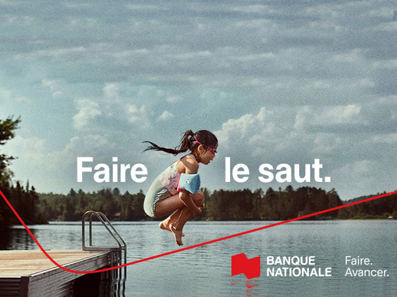 Une petite fille sautant d'un ponton dans un lac. Il est inscrit "Faire le saut" et on voit le logo de la Banque Nationale avec leur nouvelle maxime "Faire. Avancer."