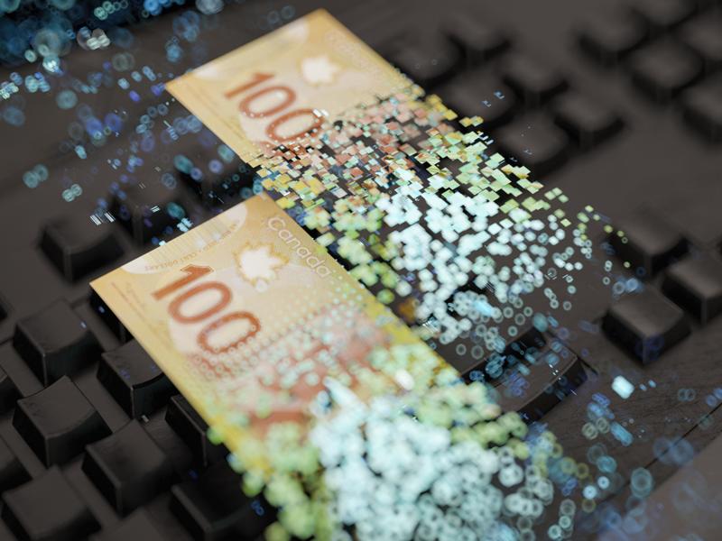 Deux billets de 100 $ canadiens sur un clavier d’ordinateur, se désintégrant en une pluie de pixels numériques.
