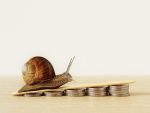 Escargot avançant sur des piles de pièces, symbole d’une croissance financière lente mais stable.