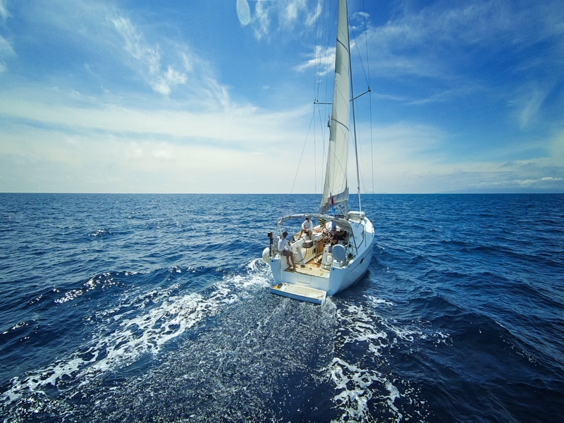 Voilier naviguant en pleine mer sous un ciel dégagé, symbole de liberté et d’évasion.