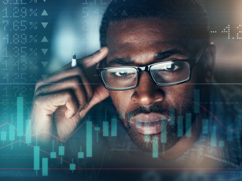 Un investisseur analyse l'évolution des marchés financiers à l'aide de graphiques boursiers et d'indicateurs économiques.