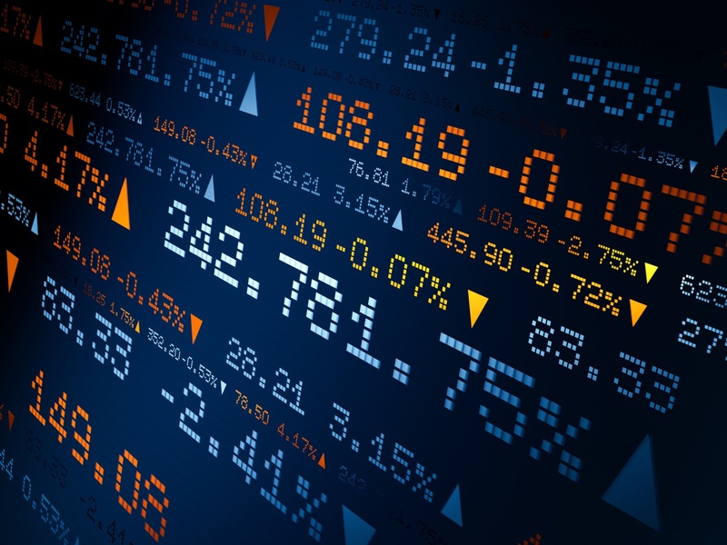 Un écran affiche des cours boursiers, des variations de prix et des indicateurs de marché.
