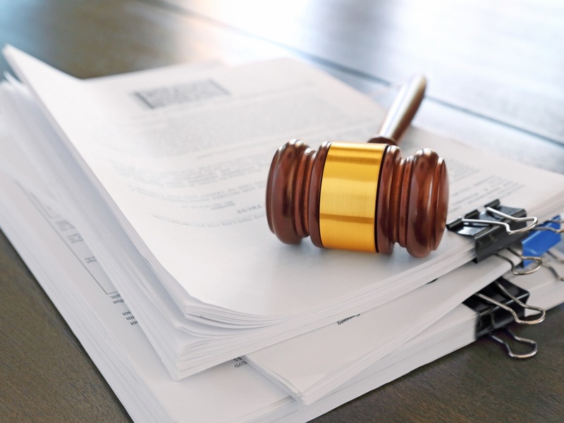 Des documents juridiques accompagnés d'un marteau de juge illustrent les procédures judiciaires et administratives.