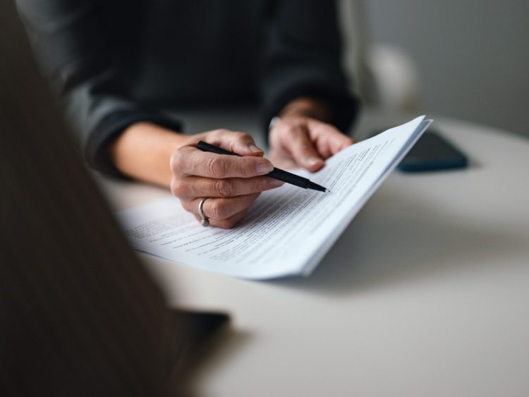 Une professionnelle examine un document juridique avant sa signature ou son dépôt.