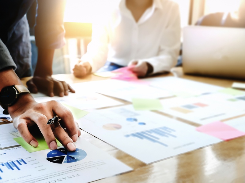 Des professionnels examinent des rapports financiers afin d'élaborer une stratégie d'affaires.